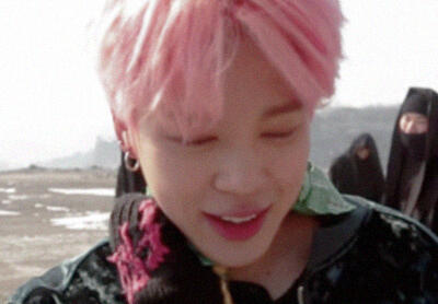 park jimin with pink hair looking down.